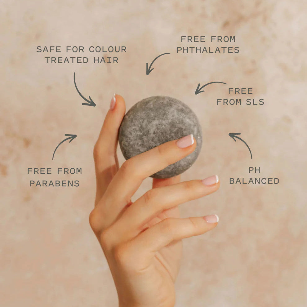 Hand holding a shampoo bar with text indicating its benefits