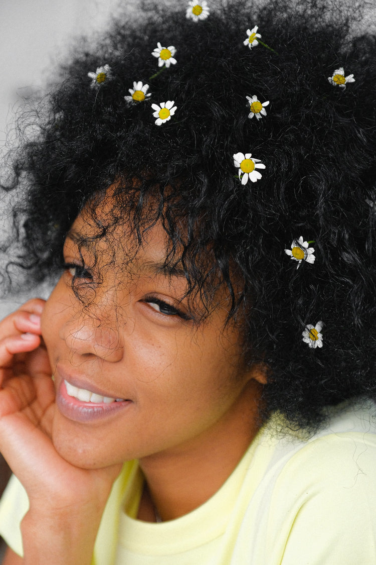 girl with afrotexture hair daisies throughout