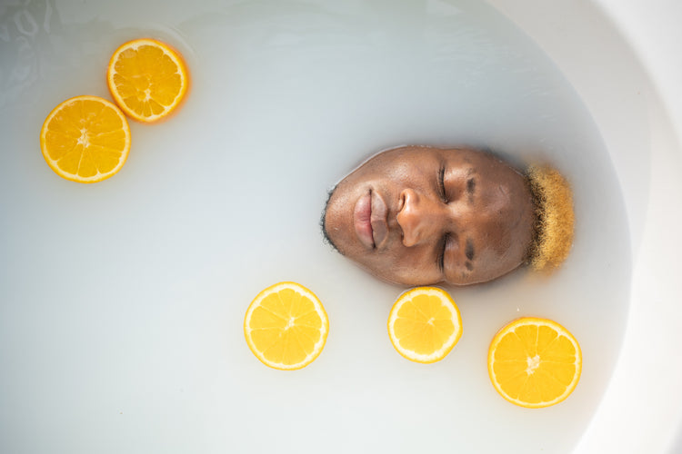 mans face in bathtub with orange slices montsera pexels