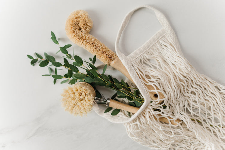 market bag with bamboo cleaning utensils and foliage