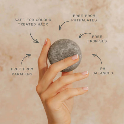Hand holding a shampoo bar with text indicating its benefits
