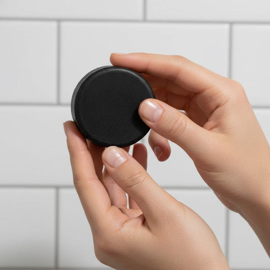 Person holding a scalp care conditioner bar against a tiled wall background